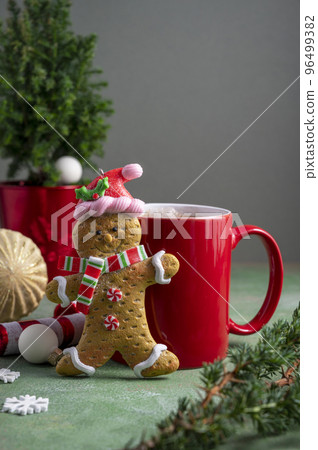 Gingerbread man and red cup with hot chocolate drink and winter ornaments. Christmas abstract background 96499382
