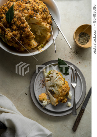 Whole cauliflower head with herbs and spices. Roasted cauliflower, top view. Whole cauliflower head with herbs and spices. Roasted cauliflower, top view. 96499386