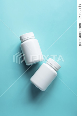 White pill bottles on blue background. Health care food supplements, vitamins and medicaments White pill bottles on blue background. Health care food supplements, vitamins and medicaments 96499415