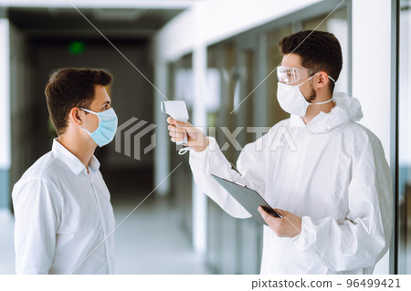 Disease control expert use an Infrared thermometer equipment to check the temperature. Disease control expert use an Infrared thermometer equipment to check the temperature. 96499421