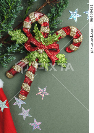 Christmas green background. Fir tree branches, seasonal ornament candy canes, stars. Creative flat lay, top view copy space 96499481