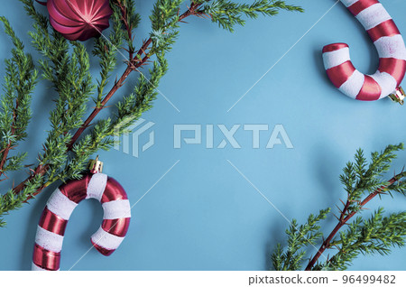 Christmas background. Fir tree branches, seasonal ornaments candy canes, stars. Creative blue flat lay, top view copy space 96499482