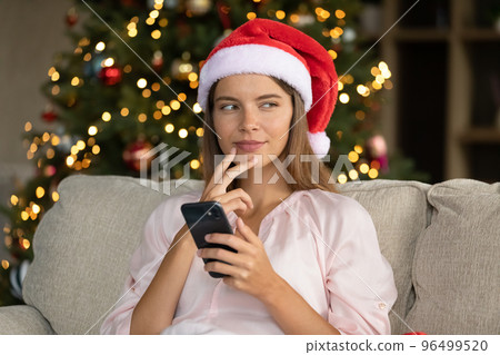 Happy young woman creating Christmas greeting at home. Happy young woman creating Christmas greeting at home. 96499520
