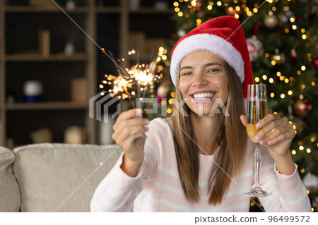 Beautiful young woman holding glass of wine and sparkles. Beautiful young woman holding glass of wine and sparkles. 96499572