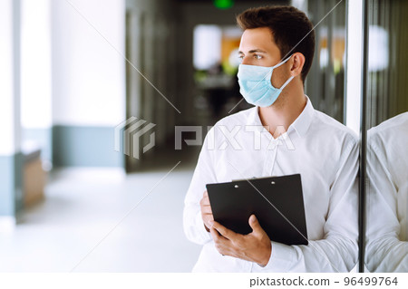 Office worker with face mask working in the office. Concept of preventing the spread of the epidemic 96499764