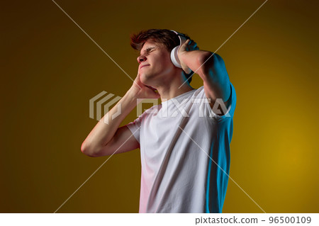 Young man listening to music with headphones 96500109