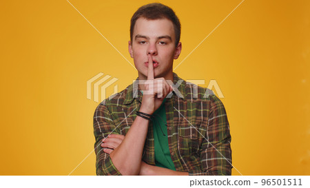 Young man presses index finger to lips makes silence gesture sign do not tells secret, shh be quiet Young man presses index finger to lips makes silence gesture sign do not tells secret, shh be quiet 96501511