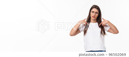 Waist-up portrait of insulted, shocked and offended young frustrated woman pointing at herself, grimace puzzled and confused, cant understand why she was picked or accused 96502069