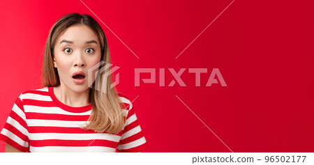 Close-up shocked alarmed speechless asian blond woman drop jaw, gasping impressed, hear shocking stunning rumor, open mouth astonished, react shook news, stand red background 96502177