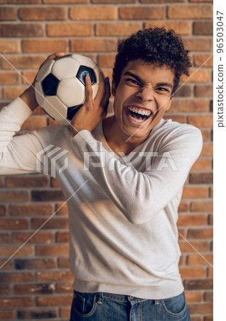 Aggressive football player posing for the camera indoors 96503047