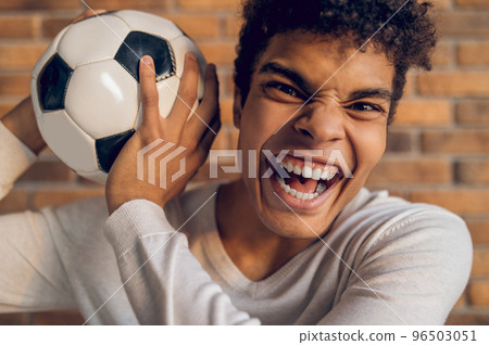 Aggressive footballer posing for the camera indoors 96503051