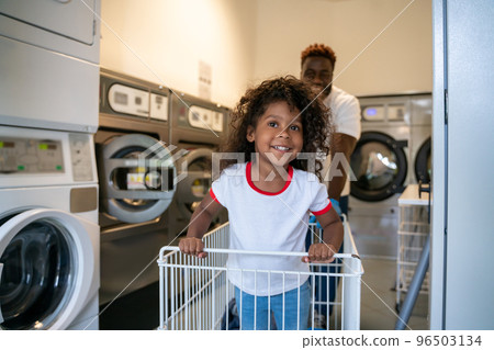 Cute kid and her dad at the launderette Cute kid and her dad at the launderette 96503134