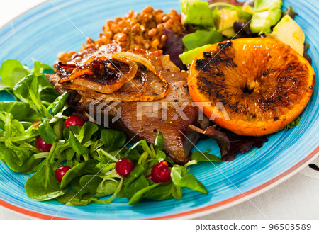 Delicious fried pork chops with avocado, fried orange and greens Delicious fried pork chops with avocado, fried orange and greens 96503589