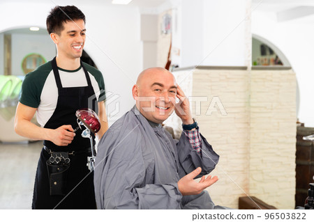 Hairdresser during washing head of positive man after shaving Hairdresser during washing head of positive man after shaving 96503822
