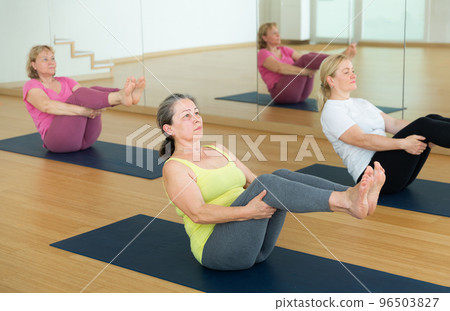 Active senior women practicing balancing yoga poses Active senior women practicing balancing yoga poses 96503827