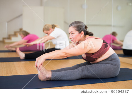 Active senior woman practicing yoga at group 96504287