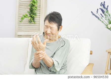 Elderly woman with hand pain at home Elderly woman with hand pain at home 96504530