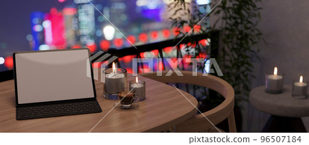 Tablet with wireless keyboard mockup and candles on table at the apartment balcony at night 96507184
