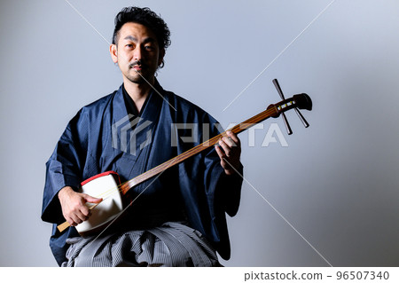 日本中年男子彈著三味線看著鏡頭 96507340