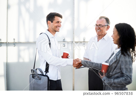 young entrepreneurs shaking hands at a chance meeting . 96507838