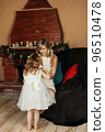 Adorable mom and daughter dress up in beautiful dresses for Christmas. Preparation for the holiday, New Year, Christmas, family holiday 96510478