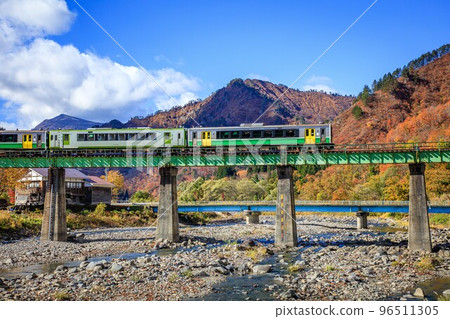 Tadami Line Train "Kiha E120 Series + Kiha 110 Series" crossing the Kanotsu River Bridge in autumn (Tadami Town, Fukushima Prefecture, November) 96511305
