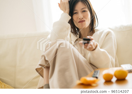 一個在房間裡放鬆的家庭主婦,一個看電視的女人 一個在房間裡放鬆的家庭主婦,一個看電視的女人 96514207