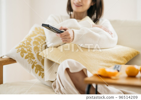 一個在房間裡放鬆的家庭主婦，一個看電視的女人 96514209