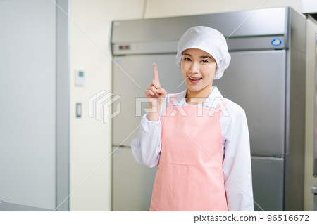 Young female cook (pointing pose) Young female cook (pointing pose) 96516672