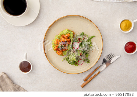 Portion of avocado toast with shrimp and salad 96517088