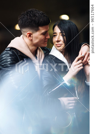 Young couple in love hug each other and kisses in underground crossing. Love story. 96517664