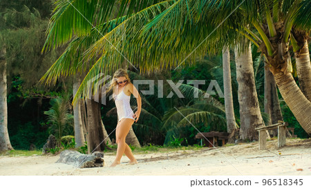 The tanned woman dances cool and appetizing on the beach of Koh Chang island in Thailand. Booty dancing twerk. Concept travel, walks, rest in sea, tropical resort traveling tourism summer holidays 96518345