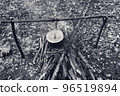 Black and white retro. Cooking in old sooty cauldron on campfire at glade 96519894