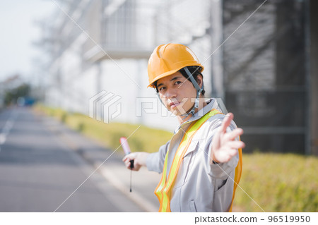 A man in work clothes directing traffic 96519950