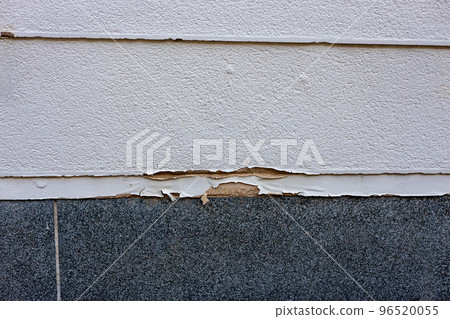 Paint on the fence of a house that has become old and peeled off 96520055