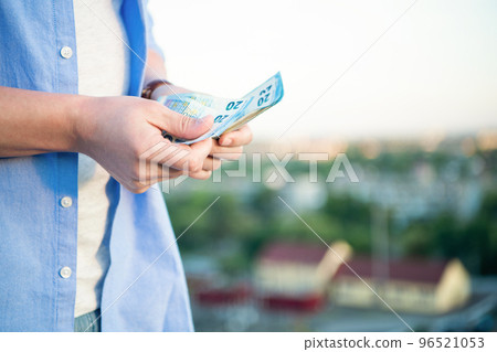 Man crop view counting cash money banknotes blur outdoors, copy space Man crop view counting cash money banknotes blur outdoors, copy space 96521053