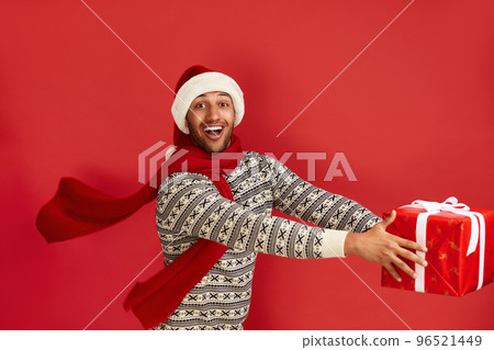 Happy Man Holding Present. Multiracial Guy in Santa Hat Holding Present Box 96521449