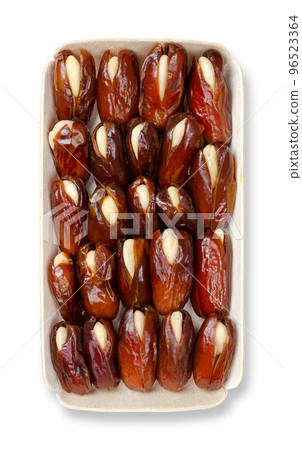 Almond-stuffed dates, in a balsa wood tray, from above. Sun dried Deglet Nour dates, pitted and filled with whole blanched almonds. A delicious sweet snack or dessert, originally from North Africa. Almond-stuffed dates, in a balsa wood tray, from above. Sun dried Deglet Nour dates, pitted and filled with whole blanched almonds. A delicious sweet snack or dessert, originally from North Africa. 96523364