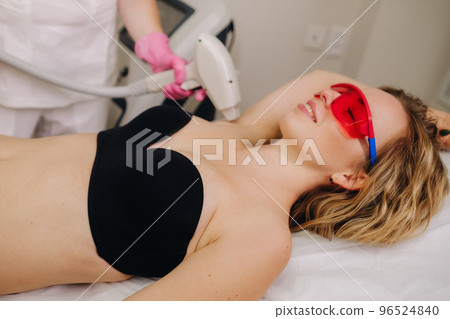 A girl in black underwear gets laser hair removal on her body in the salon A girl in black underwear gets laser hair removal on her body in the salon 96524840