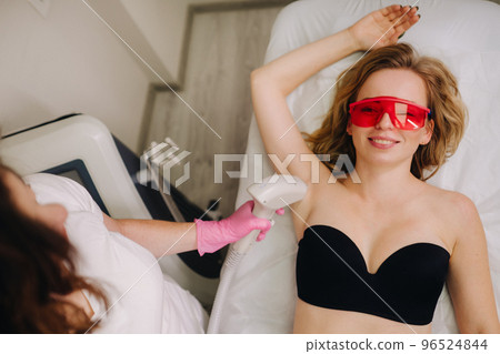 A girl in black underwear gets laser hair removal on her body in the salon A girl in black underwear gets laser hair removal on her body in the salon 96524844