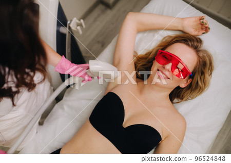 A girl in black underwear gets laser hair removal on her body in the salon A girl in black underwear gets laser hair removal on her body in the salon 96524848