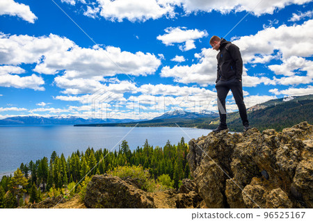 Hiker enjoying the view of Lake Tahoe from the Eagle Rock in California Hiker enjoying the view of Lake Tahoe from the Eagle Rock in California 96525167