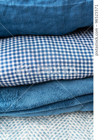 Bedclothes of different shades of blue, blue, white and different structures are stacked on top of each other, the concept of home and coziness. 96525571