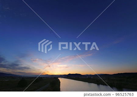 Refreshing late autumn dawn sky with waterfowl flying and a river reflecting the sky・Super wide angle・Sky mainly・221030am 96525763