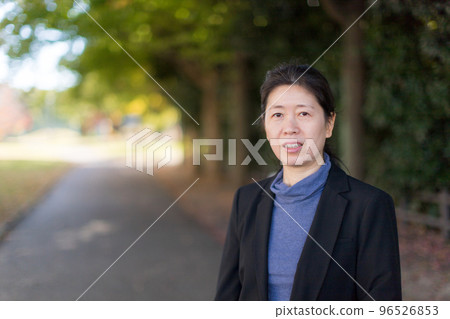 秋季公園散步的中年婦女圖 96526853