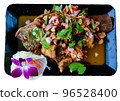 Fried fish decorated with beautiful vegetables on a black plate 96528400