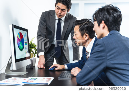 Businessmen having a meeting while looking at a computer screen 96529010