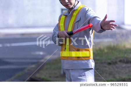 一個穿著工作服的男人在指揮交通 96529331