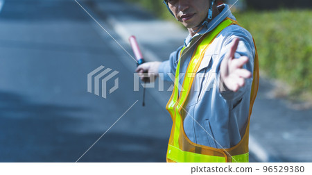 A man in work clothes directing traffic A man in work clothes directing traffic 96529380