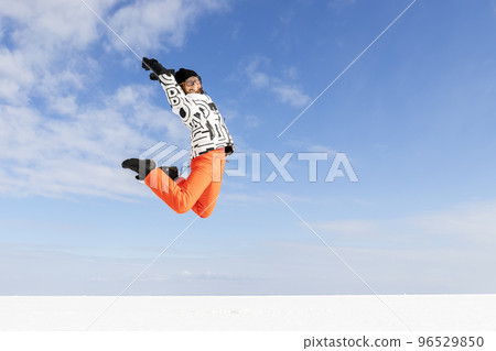 Young adult beautiful sporty happy attractive caucasian smiling hiker woman enjoy jumping high frozen lake surface panorama horizon background. Winter travel freedom outdoors adventure trip concept 96529850